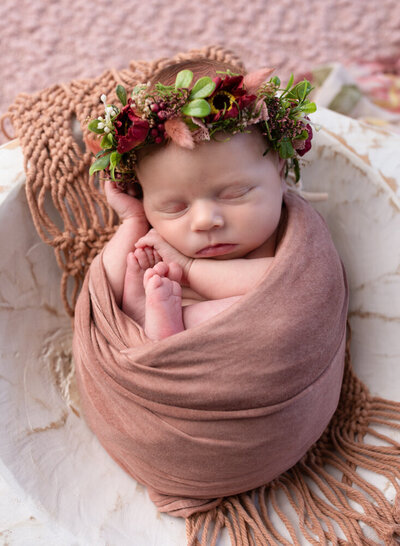 Days-old newborn baby wrapped in pink fabric by SLC newborn photographer, Diane Owen