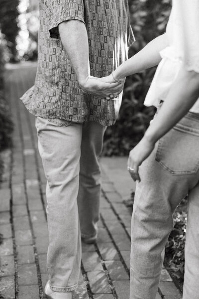 couple holding hands while the male leads the way