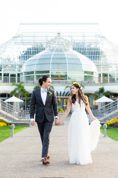 Bride and groom walking in front of Phipps Conservatory