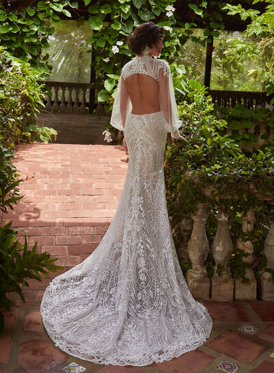 Ivory stretch lace in a sheath silhouette. Long sleeves iwth a scalloped back and cascading train.
