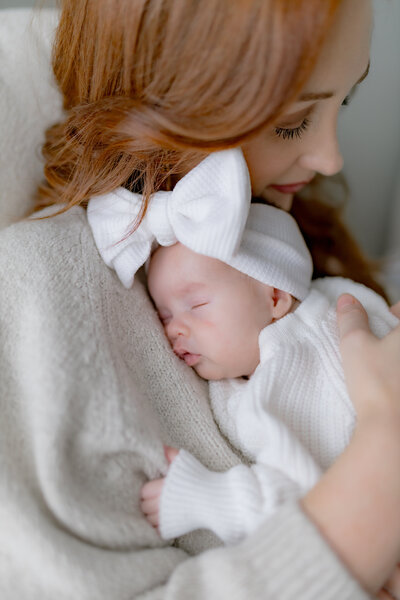 newborn lifestyle in louisville ky natural light baby snuggled on mom in rocking chair
