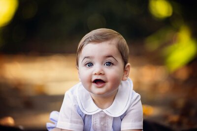 A smiling baby boy with bright blue eyes, radiating joy and innocence.