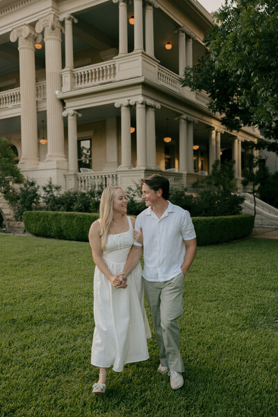 Kennedy and Tyler's engagement photos in white in front of a house