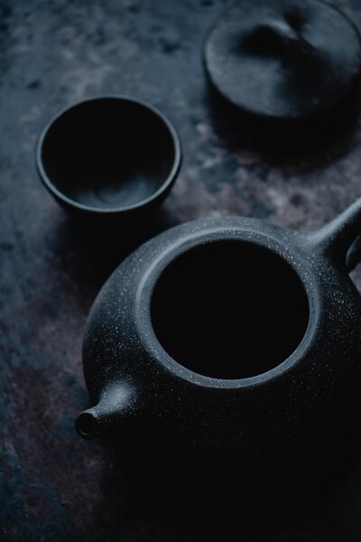 dark stone tea pot with matching small tea cup without handles