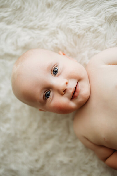 Seven month old baby laying on his back for his baby milestone photo session