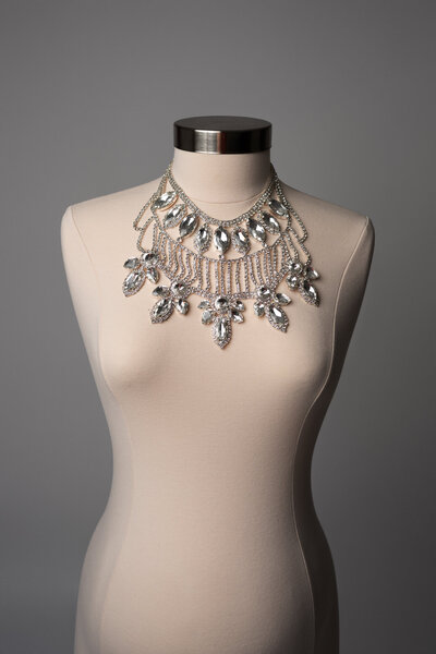 Pregnant woman wearing a statement pearl shoulder piece in a fine art maternity photo