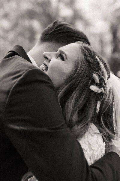 Tear rolling down bride's cheek while groom is hugging her during first look