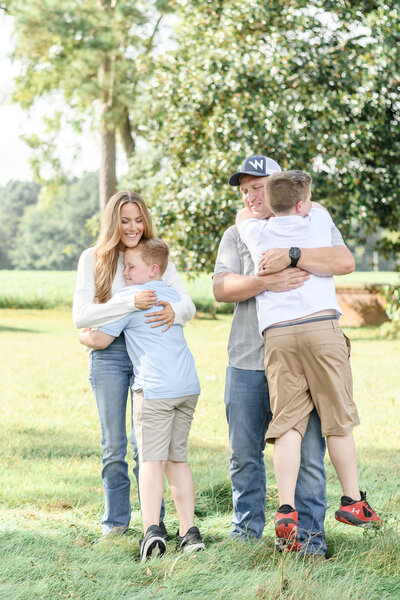 Sons hugging their parents during family photos