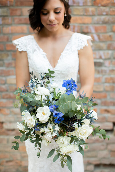 Bride looks down at bouquet she is holding in her hands