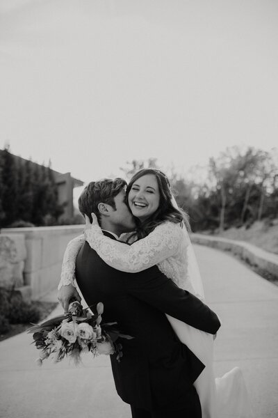 bride and groom holding eachother while laughing
