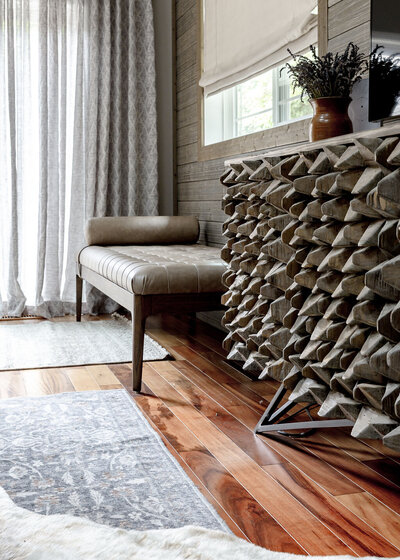 Farmhouse interior design by Winsome Home Interiors featuring a textured tv stand, rug and ottoman.