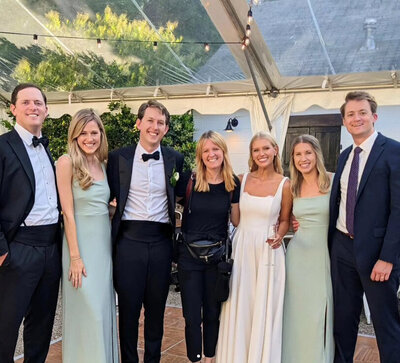 Meghan, an experienced hybrid film wedding photographer taking a selfie with past clients.