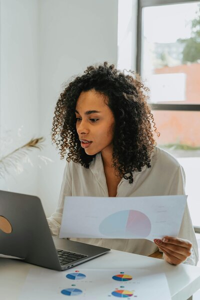 Female looking at her computer and reviewing data through graphs