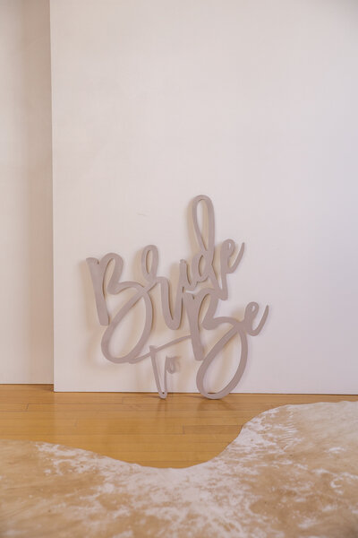 A taupe sign that says Bride to Be.
