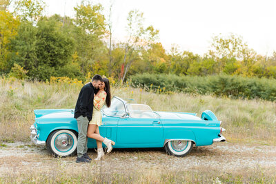 man and woman in front of vintage car