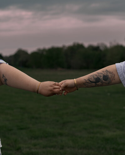 lgbt couple holding hands close-up during blue hour sunset at coxhall gardens