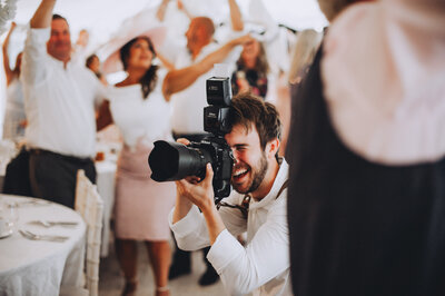 Tom Keenan laughing whilst taking photographs at a wedding at Marleybrook House in Kent