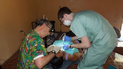 dentists practicing dental care on patient