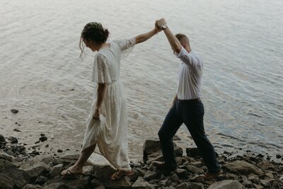 bride leads groom along the shore during their Newfoundland elopement