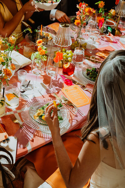 Candid moment of bride sitting and savoring her meal at the wedding dinner table