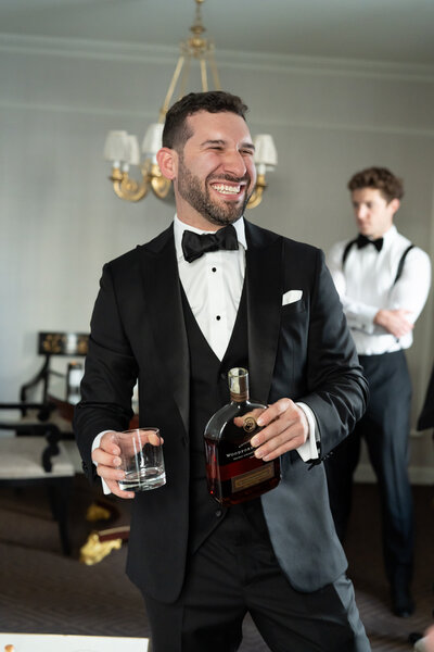 A candid moment of a groom in his getting ready suite at the Willard Hotel in Washington DC. Captured by Caitlin Wilcox Photography, a wedding photographer based in Virginia.