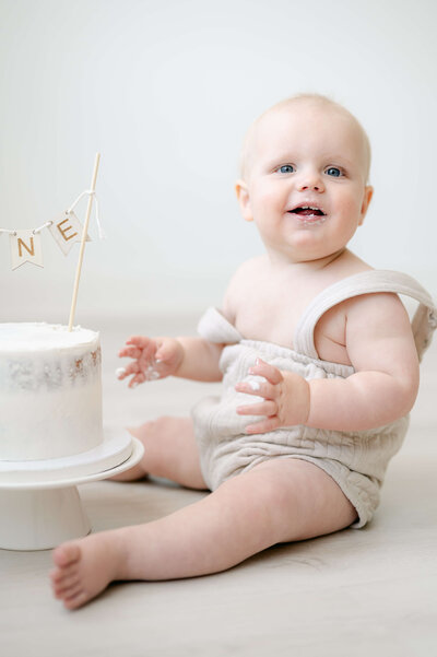 little boy eating smash cake wearing H&M outfit