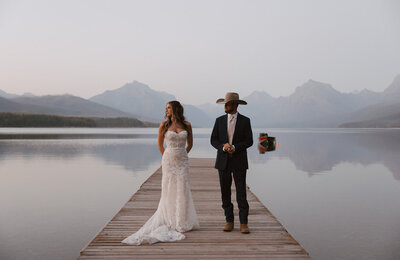 Couple standing on dock during an elopement at Grand Teton National Park with mountain peaks in the background.