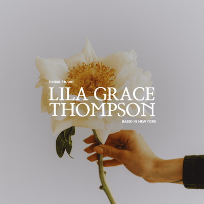 Close-up of a hand holding a delicate white peony flower against a soft, neutral background. Text overlay reads "Lila Grace Thompson Floral Studio" with the tagline "Based in New York."