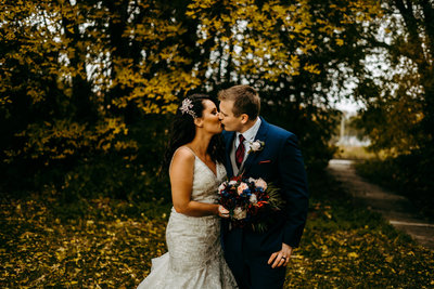 Married couple in fall leaves kissing