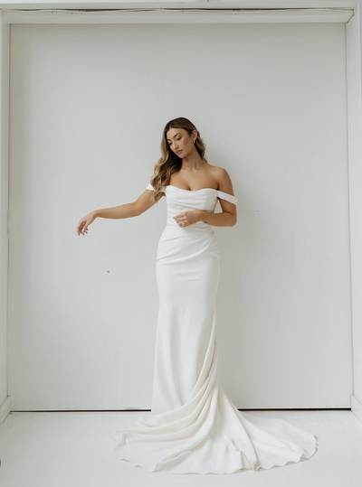 Bride posing in fitted wedding dress.