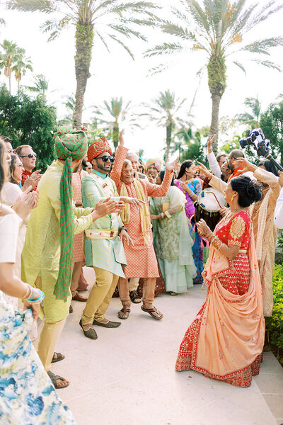 Joyful baraat procession with family and friends dancing during an Indian wedding celebration at The Ritz Carlton Sarasota, filled with vibrant colors and cultural tradition — photographed by Asia Pimentel.