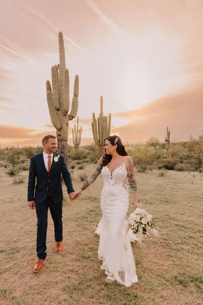 bride and groom walking near cactus