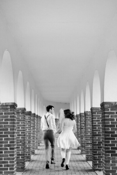 black and white image bride and groom holding hands
