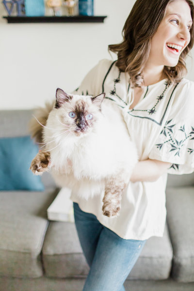 wedding planner Sarah holding Ragdoll cat and smiling