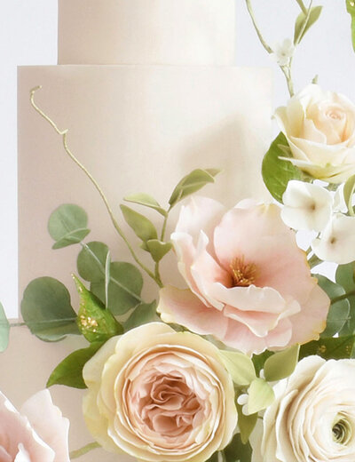 Closeup of pale pink sugar flowers and wild foliage