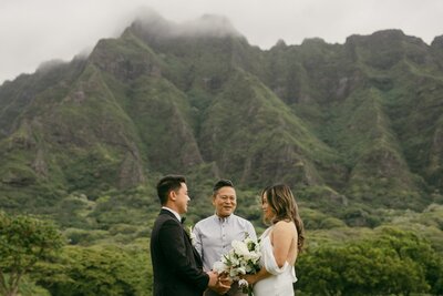 Oahu wedding photographer documents flower girls dancing in field.
