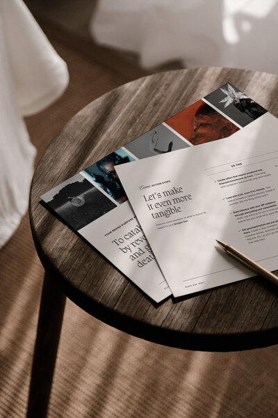 Flat lay of astro brand strategy documents and creative direction guide on a wooden table, part of the Moonstone Brand Star Chart process.