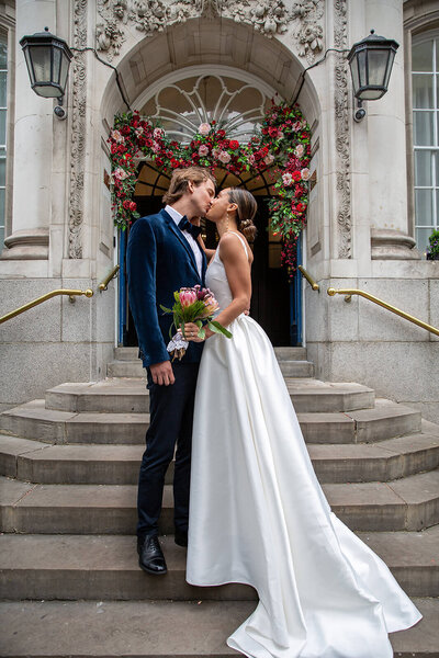 Bride and groom embrace on Chelsea Town Hall steps