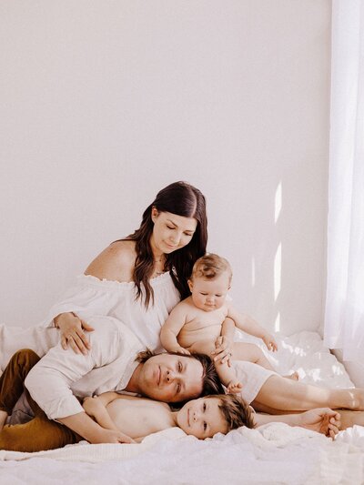 Lifestyle family photo of mom dad and children in bed