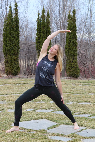 Andrea holding a yoga pose on concrete bricks