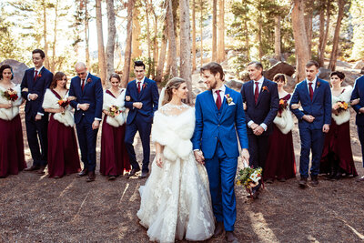 Bridal party takes photos in forest on top of a mountain in California.