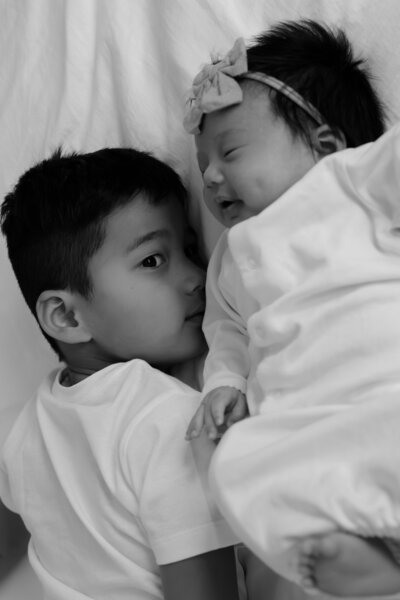 Newborn and brother laying down together