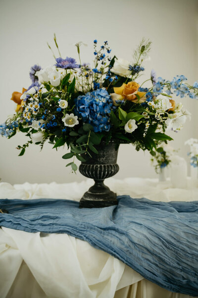 A large floral arrangement with blue, yellow, and white flowers.