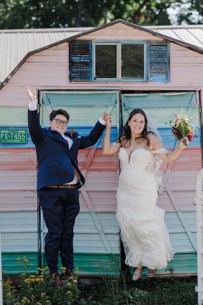 LGBTQ brides jump for joy during Colorado summer small wedding.