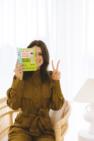 copywriter reads a book and does peace sign
