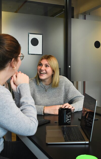 A world of strategic engagement as our expert team, elegantly dressed in grey outfits, conducts a meeting with an incredible client. The meeting room is set with a laptop on the table, showcasing a collaborative and professional atmosphere