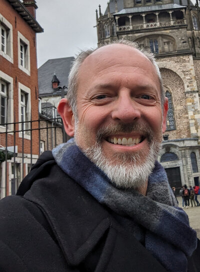 Before photo of man outdoors in scarf and coat, casual selfie taken prior to professional online dating photo session in Minneapolis