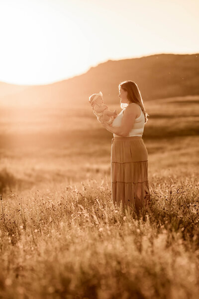 Mother looks at her baby girl in a field in Oklahoma.