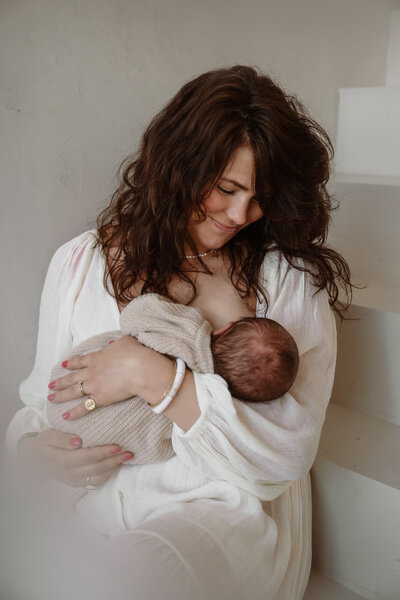 Borstvoeding sessie tijdens newbornshoot in daglicht studio