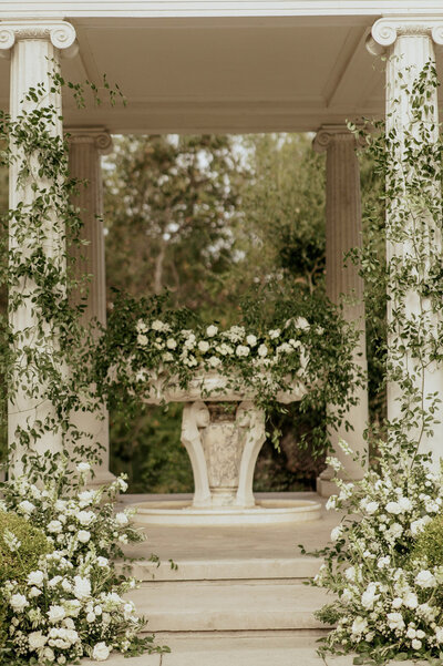 Classic outdoor wedding altar with white florals and greenery